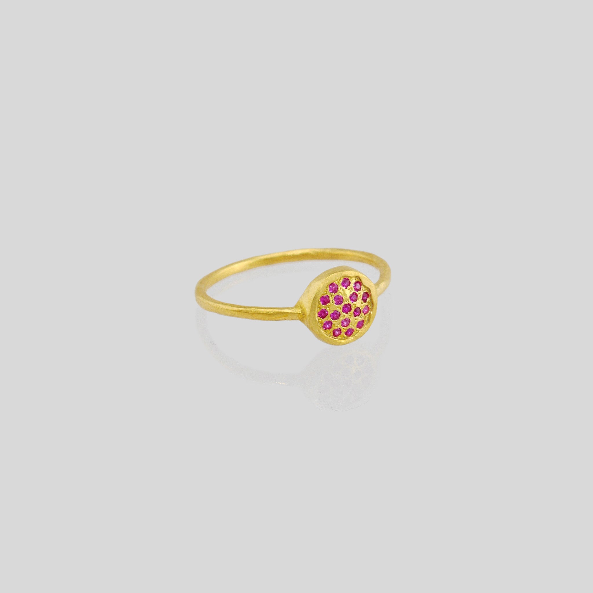 Delicate hand-made gold ring with a circular plate set with tiny Ruby gemstones. The sparkle from the stones resembles a starry night.
