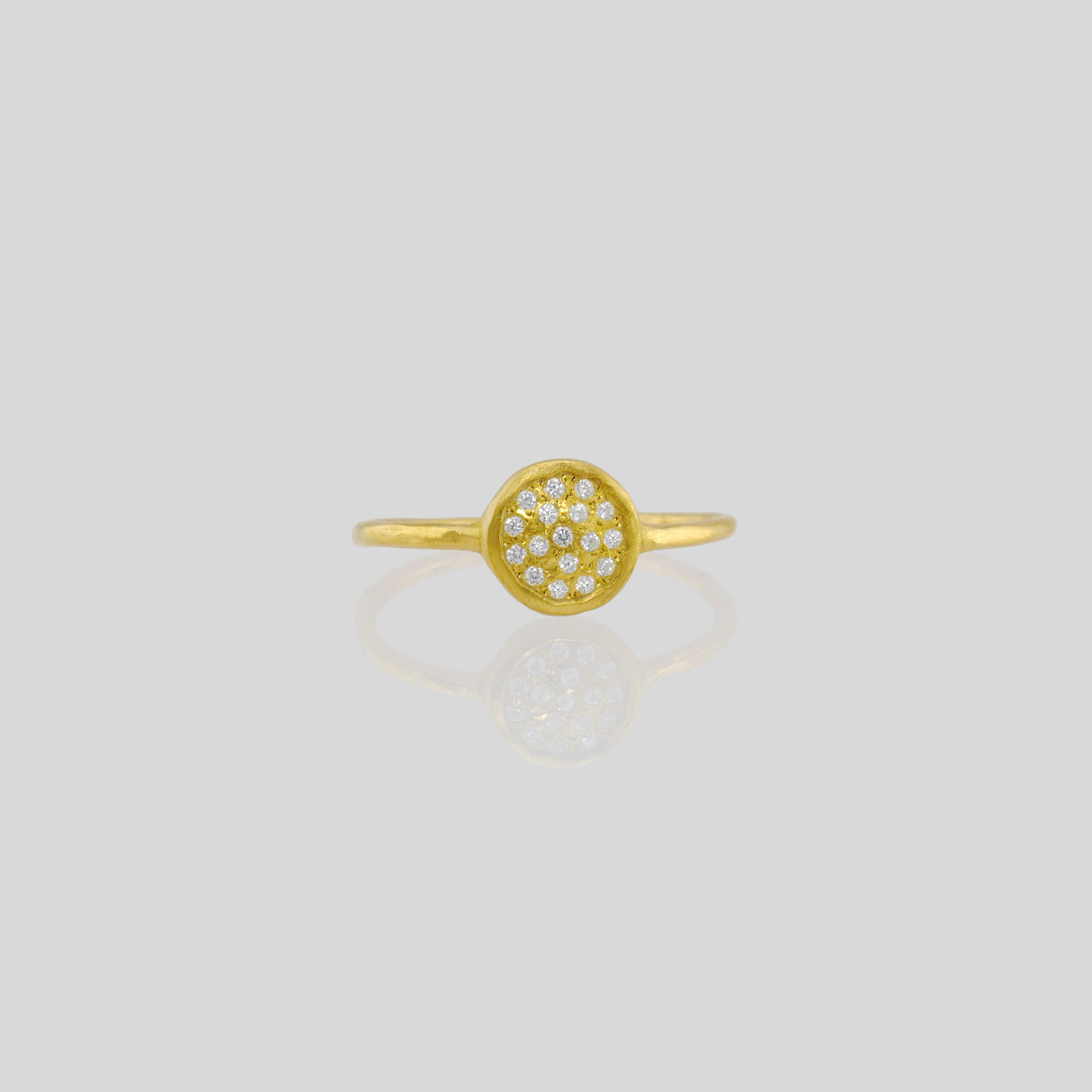 Front view of a Delicate hand-made 18k Gold ring with a circular plate set with tiny Diamonds. The sparkle from the stones resembles a starry night.