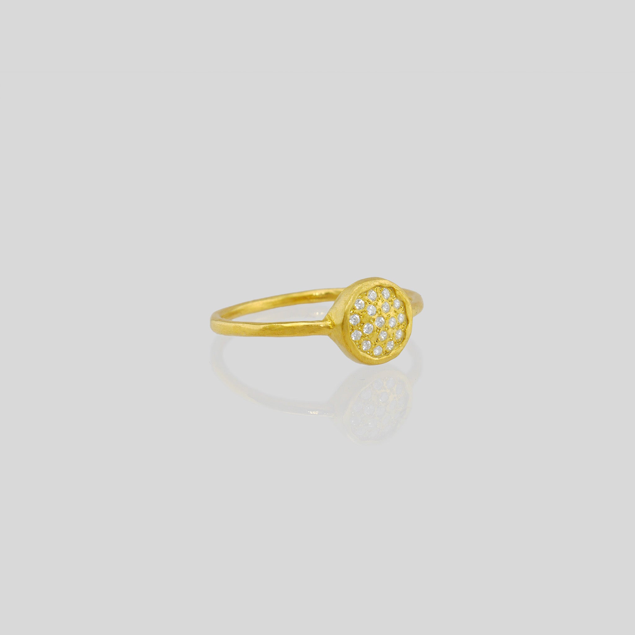 Delicate hand-made 18k Gold ring with a circular plate set with tiny Diamonds. The sparkle from the stones resembles a starry night.