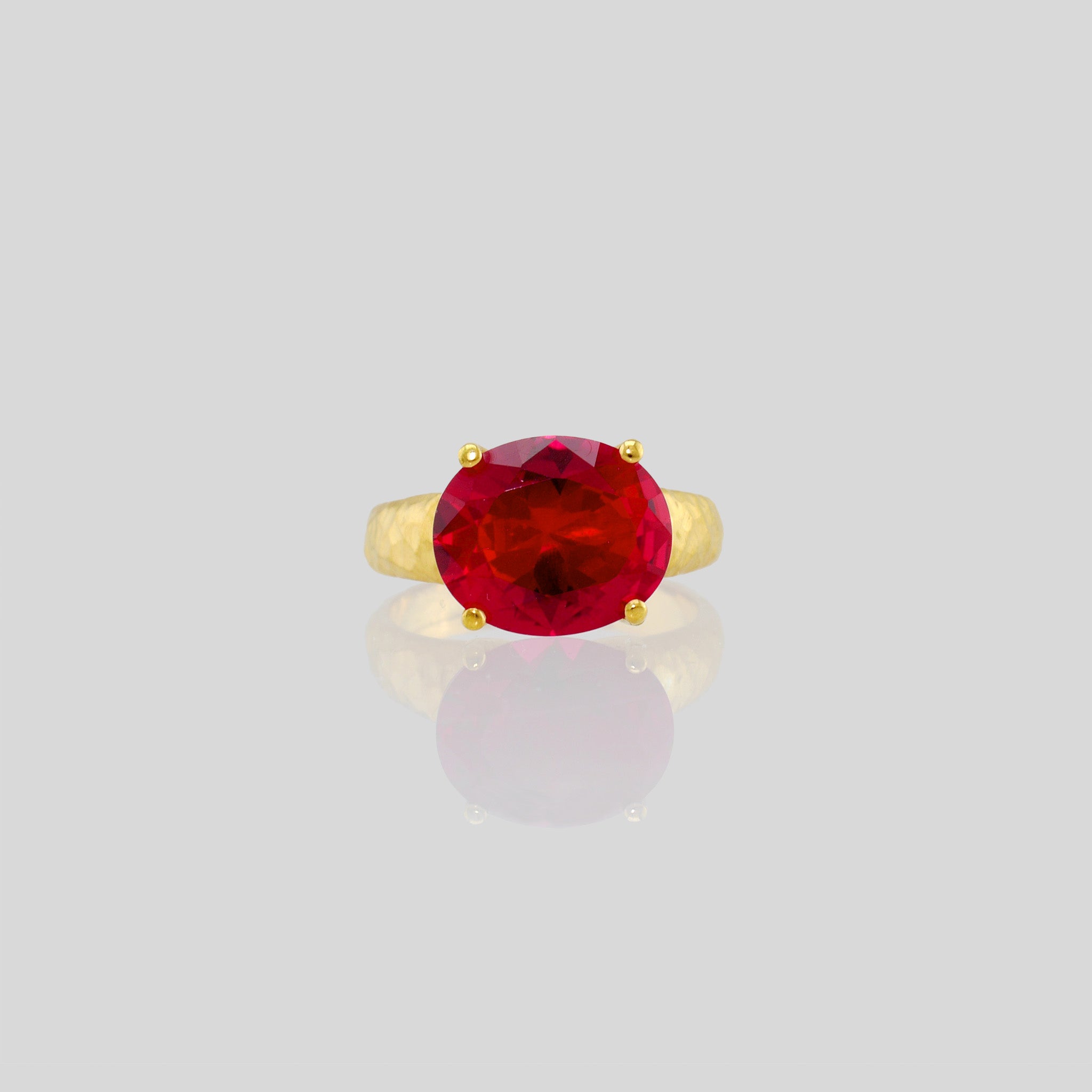 Front view of 18k Gold ring featuring four stems holding an elliptic Ruby, combining rich color depth with a dignified presence.