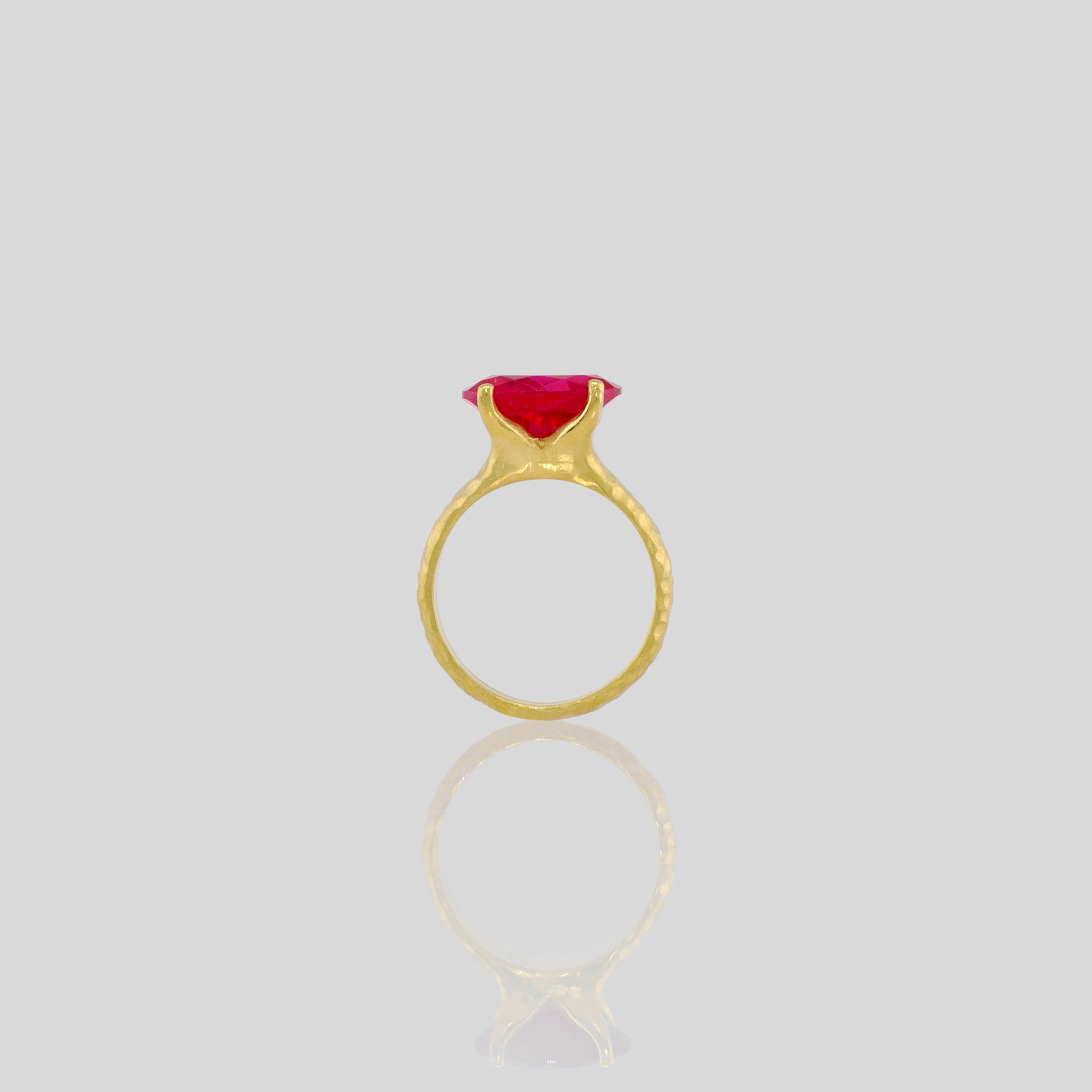 18k Gold ring featuring four stems holding an elliptic Ruby, combining rich color depth with a dignified presence.