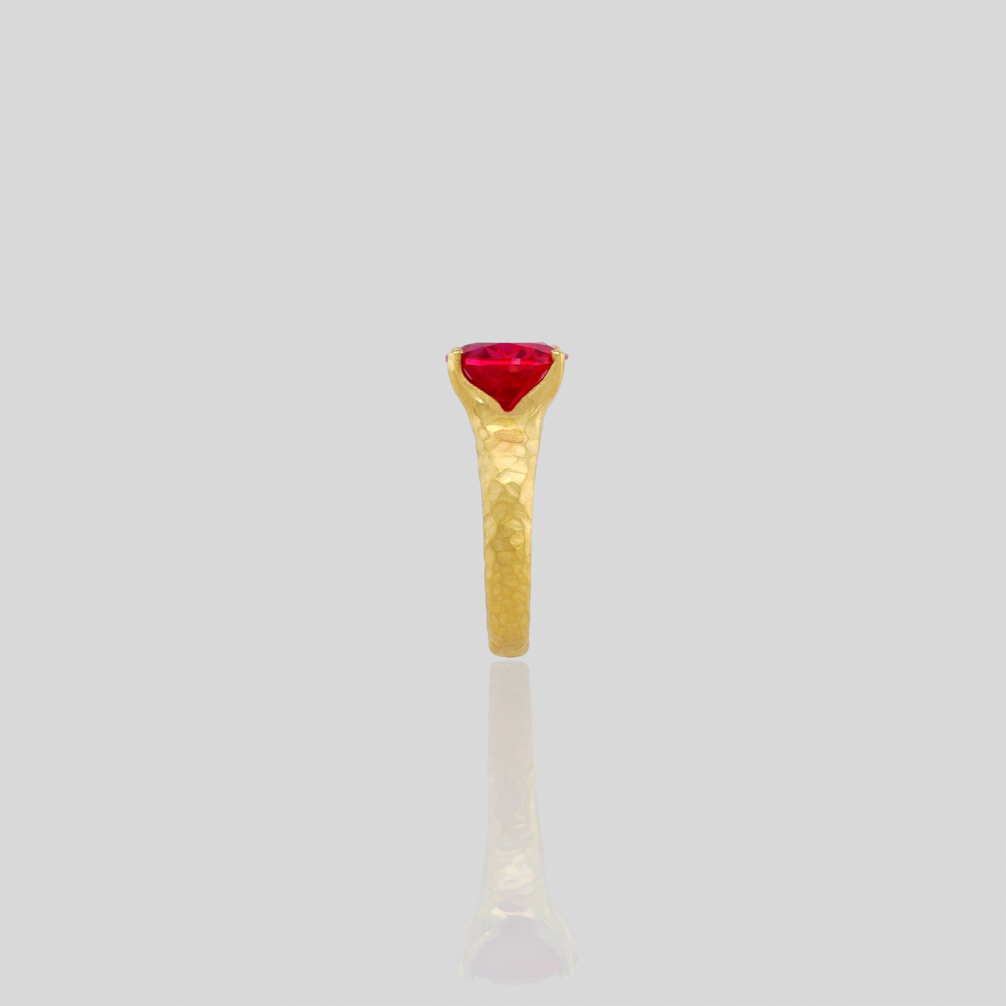 Side view of 18k Gold ring featuring four stems holding an elliptic Ruby, combining rich color depth with a dignified presence.
