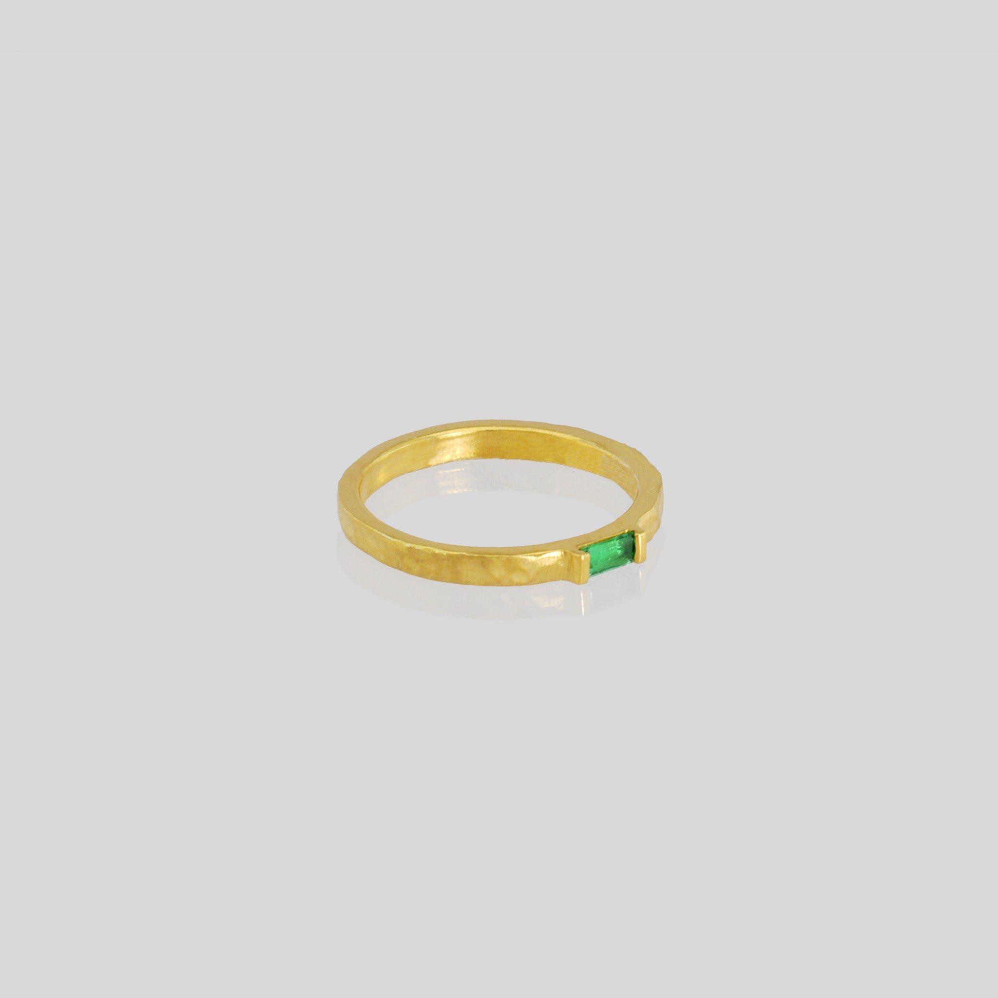 Handmade gold ring with hand-hammered surface and baguette Emerald accent. Timeless elegance in Yellow gold, a perfect addition to any ensemble.