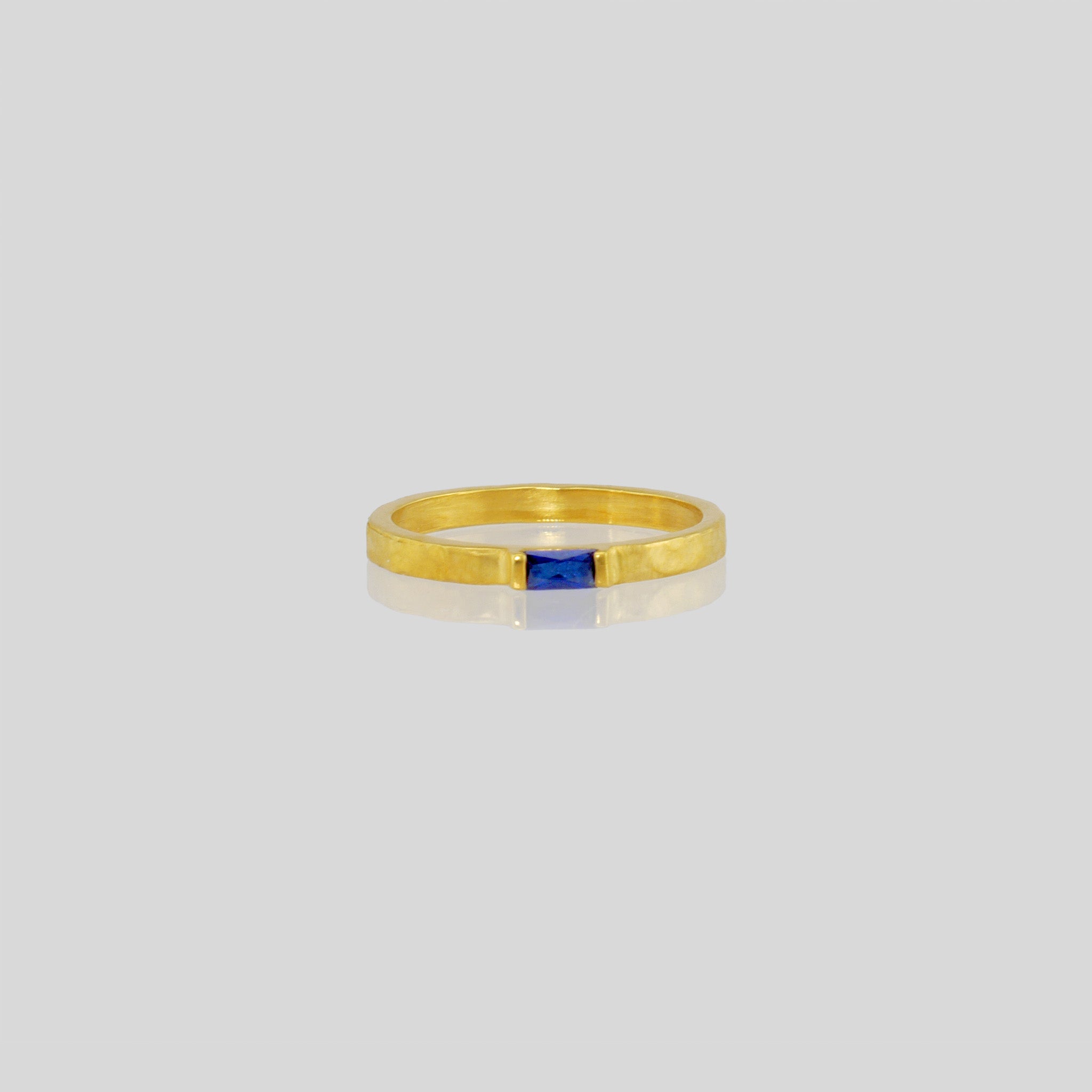 Handmade gold ring with hand-hammered surface and baguette Sapphire accent. Timeless elegance in Yellow gold, a perfect addition to any ensemble.