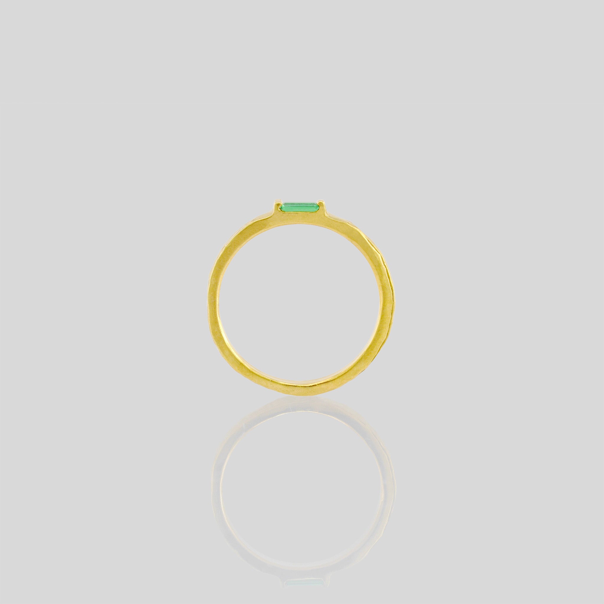 Side view of Handmade gold ring with hand-hammered surface and baguette Emerald accent. Timeless elegance in Yellow gold, a perfect addition to any ensemble.