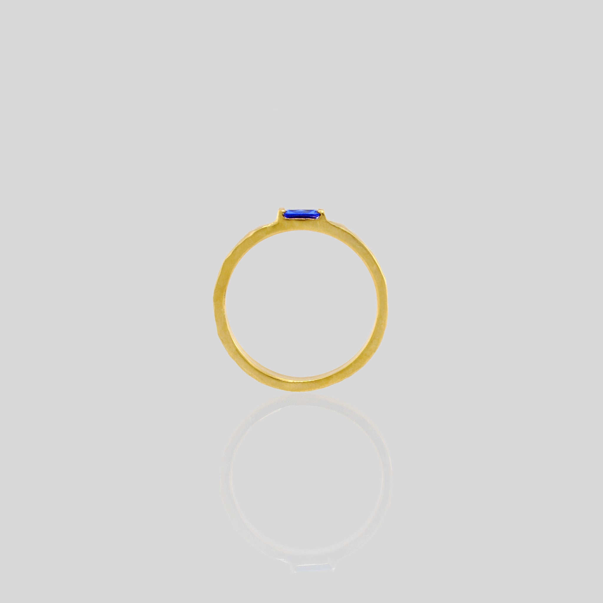 Side view of Handmade gold ring with hand-hammered surface and baguette Sapphire accent. Timeless elegance in Yellow gold, a perfect addition to any ensemble.