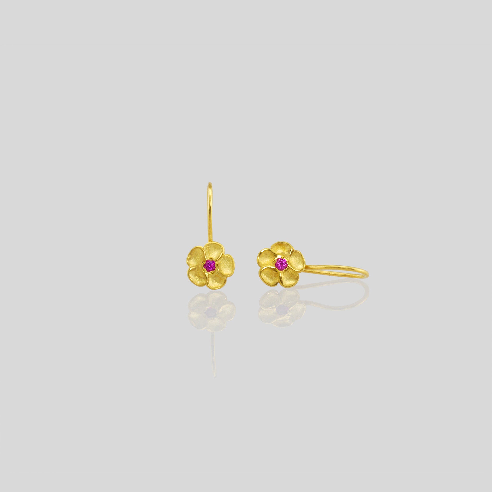 Delicate yellow gold flower drop earrings with a sparkling ruby center. Perfect for any occasion!