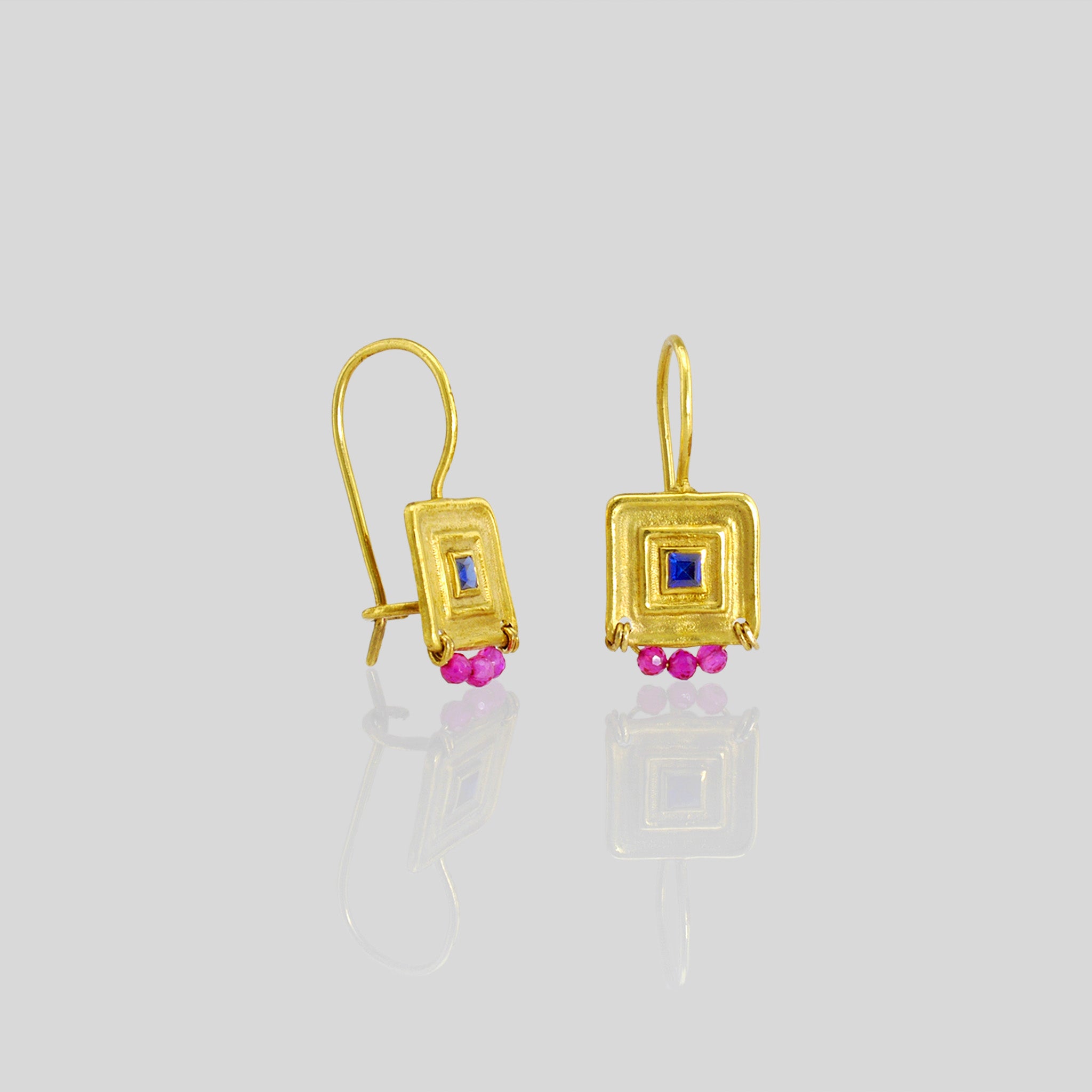 Unique gold square drop earrings featuring a square sapphire gemstone framed by a line pattern, with three hand-woven ruby beads at the bottom for an elegant Egyptian vibe.