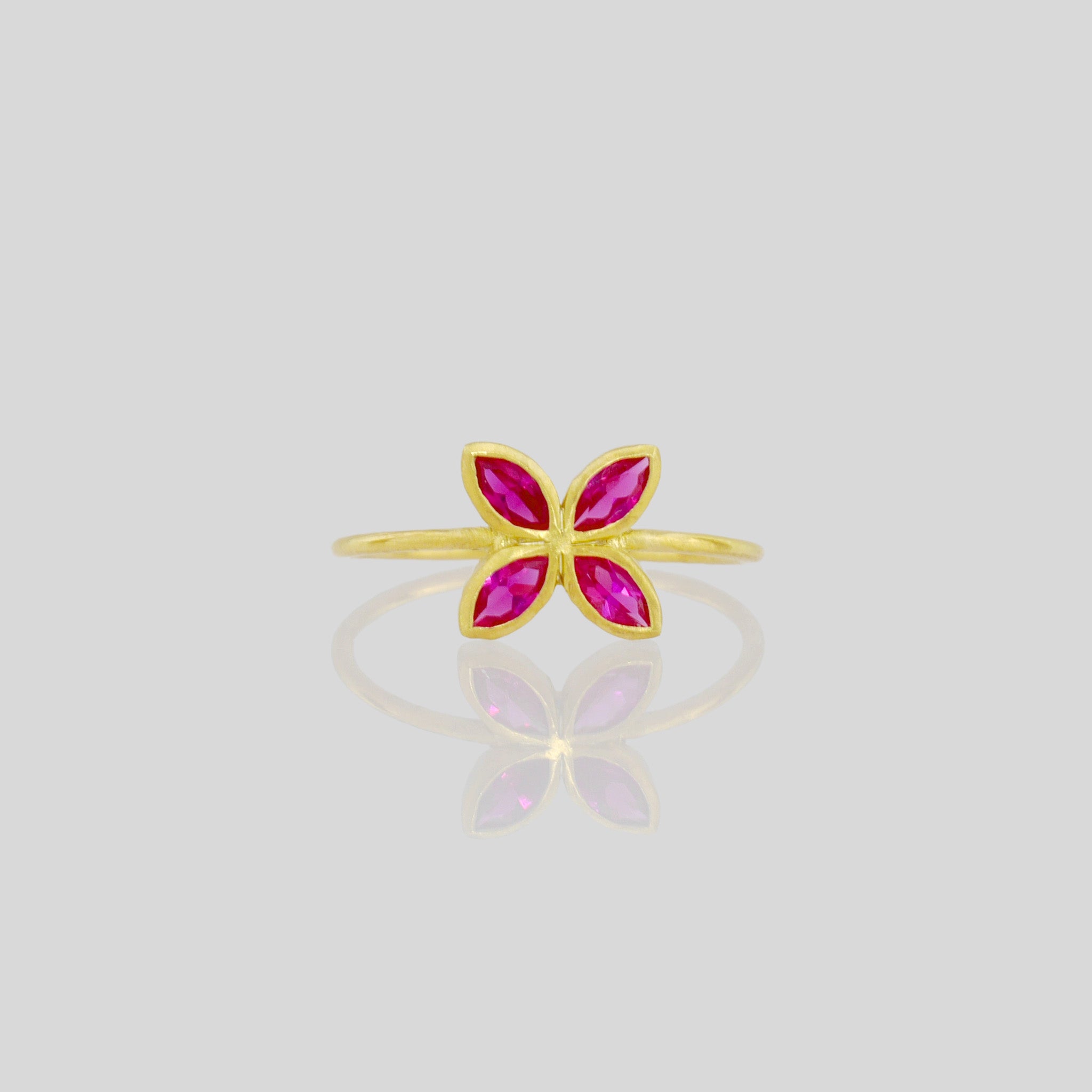 Front view of Delicate Gold ring with Ruby marquise in a flower-shaped design. Radiant and cheerful addition to any collection.