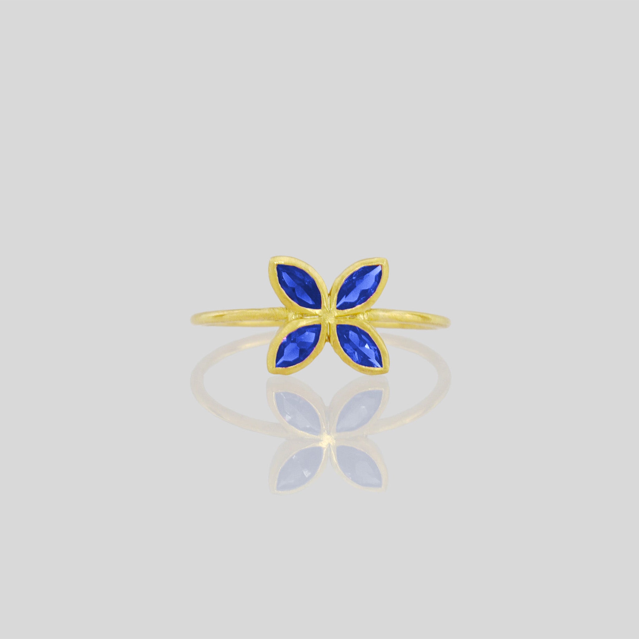 front view of Delicate Gold ring with Sapphire marquise in a flower-shaped design. Radiant and cheerful addition to any collection.