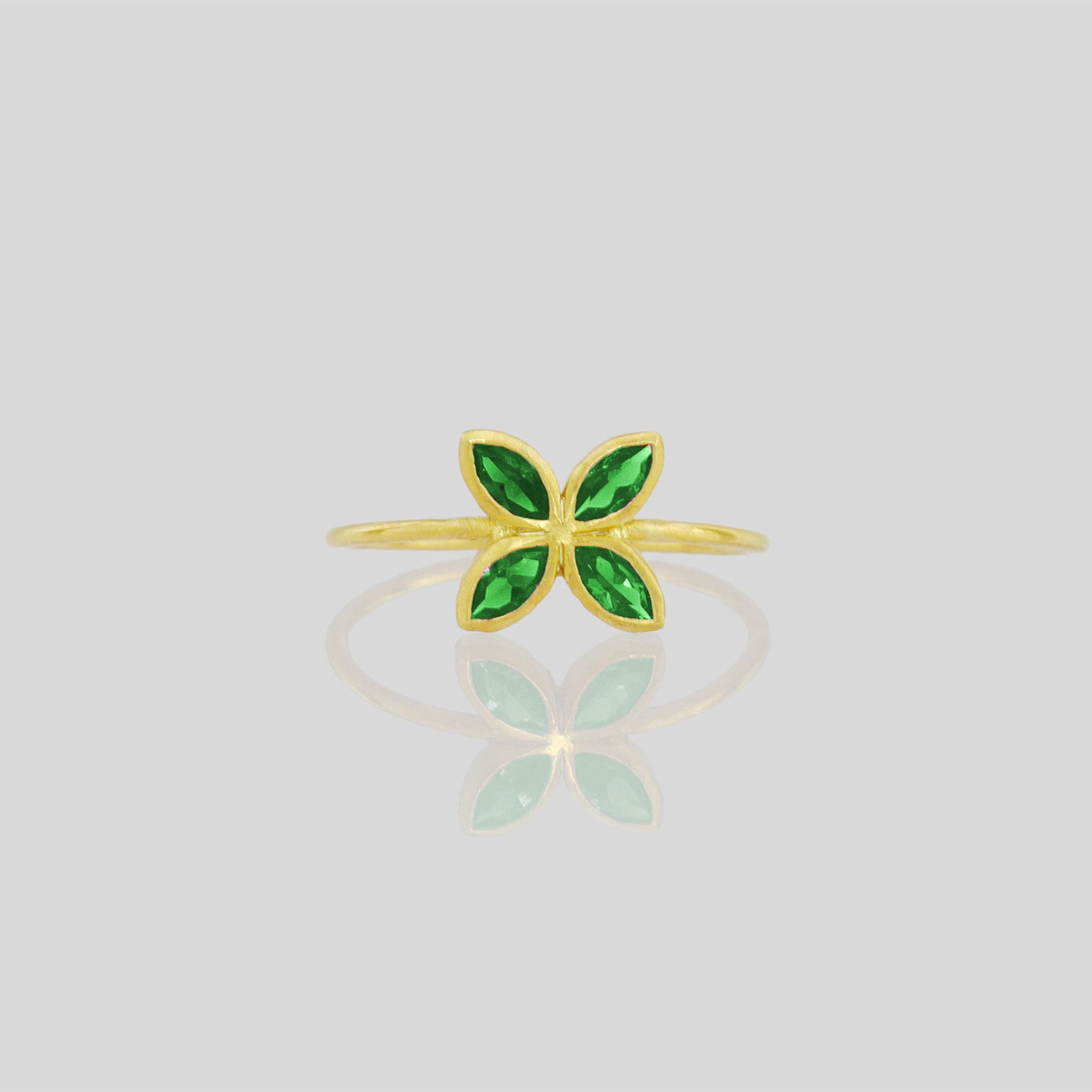 Front view of Delicate Gold ring with Emerald marquee in a flower-shaped design. Radiant and cheerful addition to any collection.