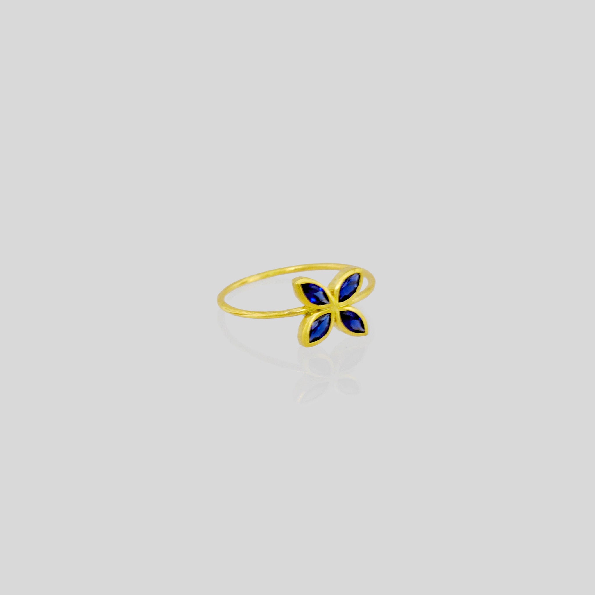 Delicate Gold ring with Sapphire marquee in a flower-shaped design. Radiant and cheerful addition to any collection.