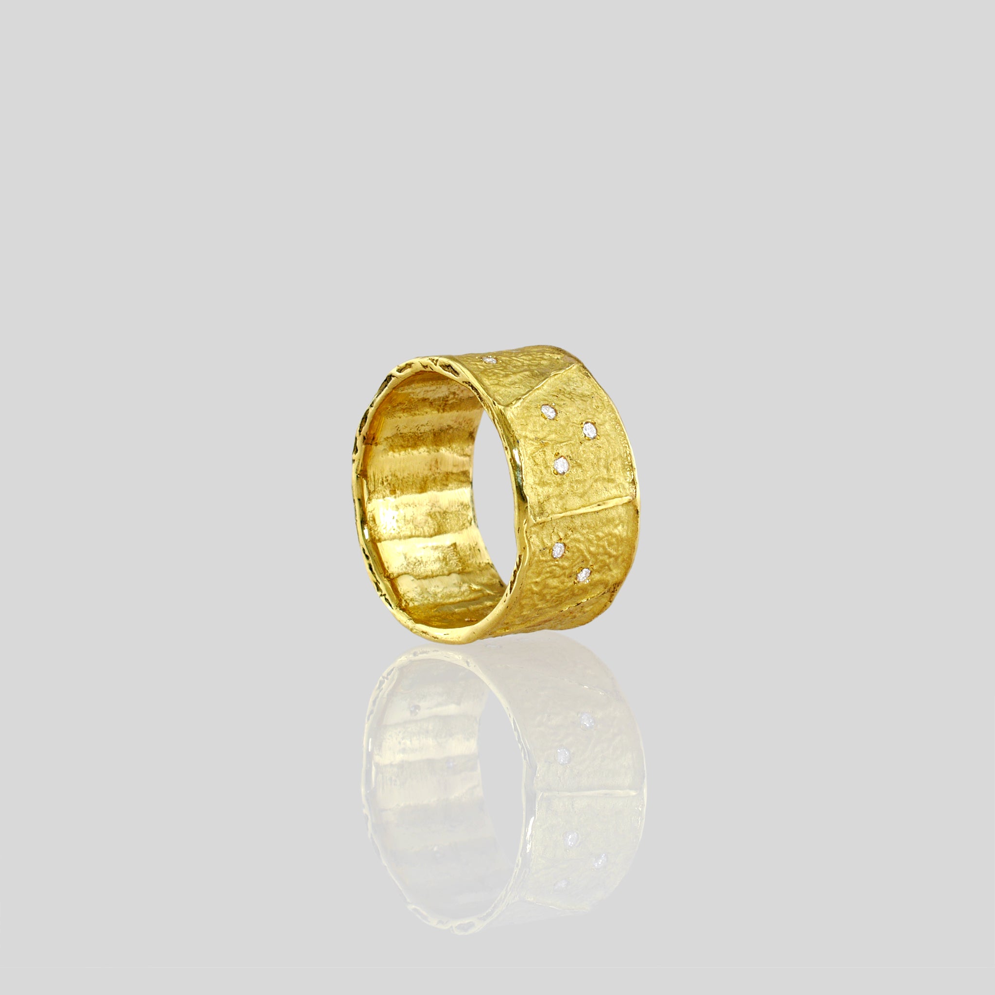 A stunning 18k Yellow Gold Ring featuring a unique wrinkled texture inspired by ancient Egyptian artistry, elegantly adorned with tiny sparkling diamonds for a timeless charm.
