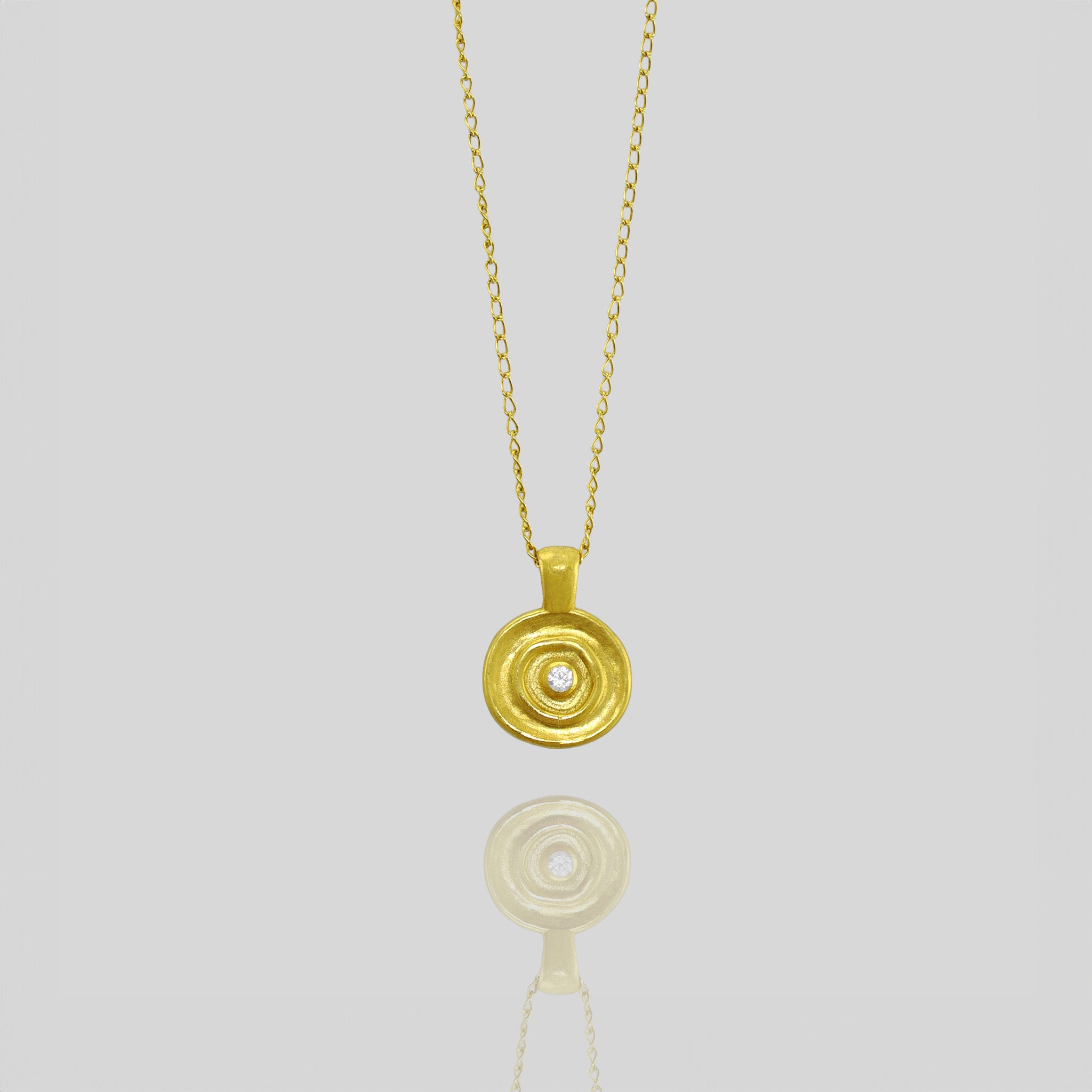 Handcrafted round pendant in yellow gold, featuring a central diamond inspired by ancient Egyptian Pharaohs' jewelry.
