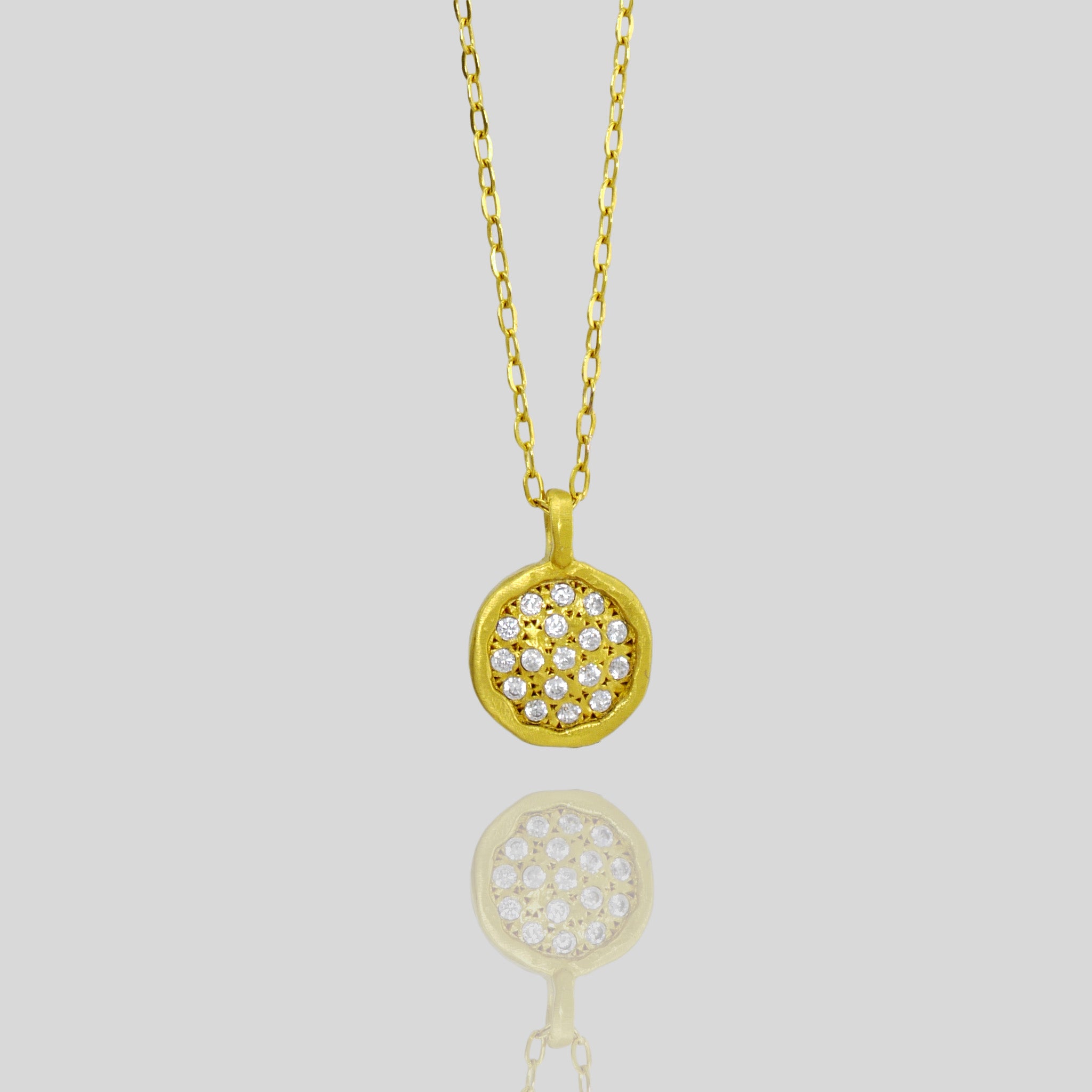 Close up of Starlit gold pendant, expertly handcrafted from Yellow Gold with a small gold plate peppered with scattered tiny Diamonds, invoking the beauty of a starry night sky.