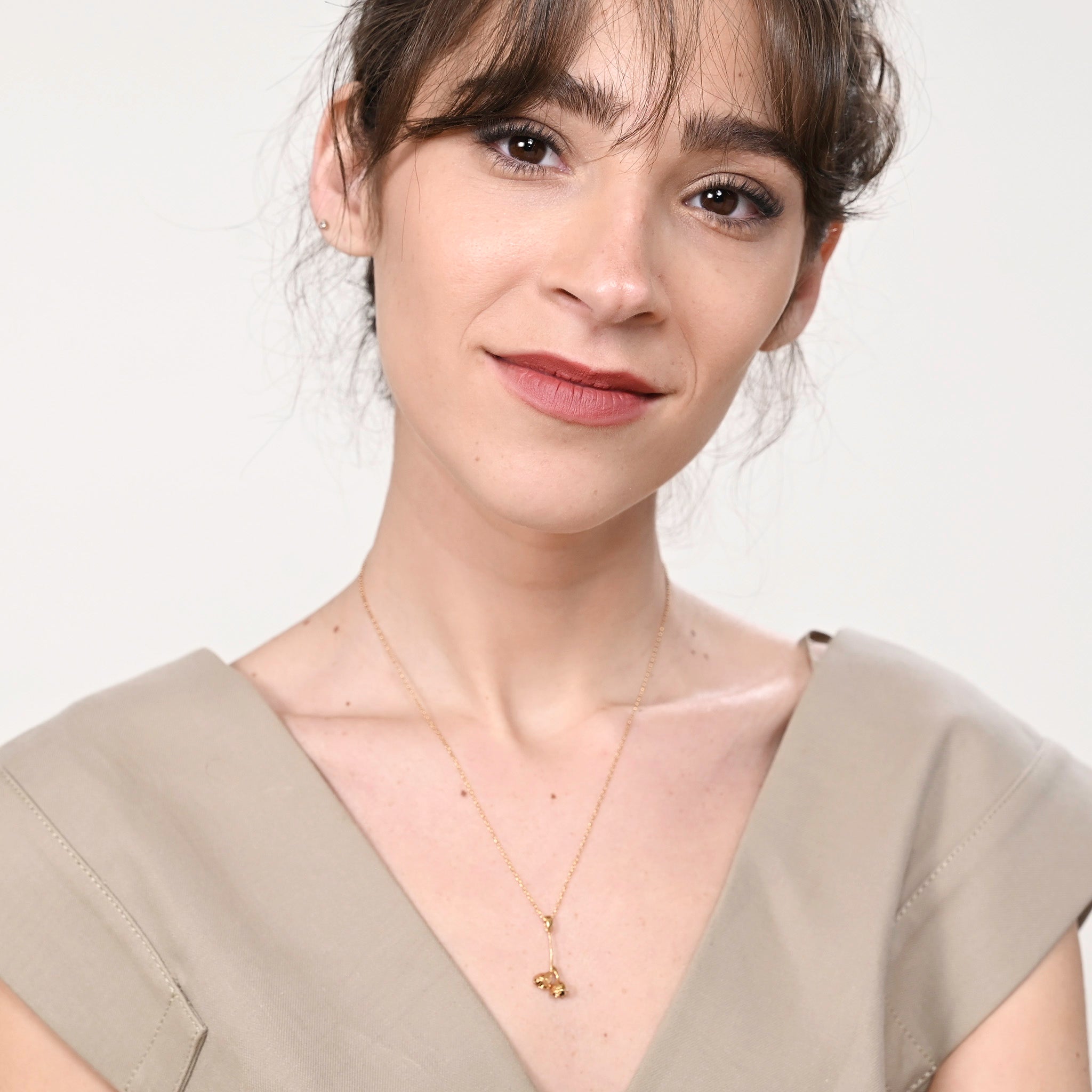 Model wearing a gold Eucalyptus seed necklace, showcasing the detailed craftsmanship of the small eucalyptus branch design with dried seed pods, adding a touch of nature-inspired elegance.