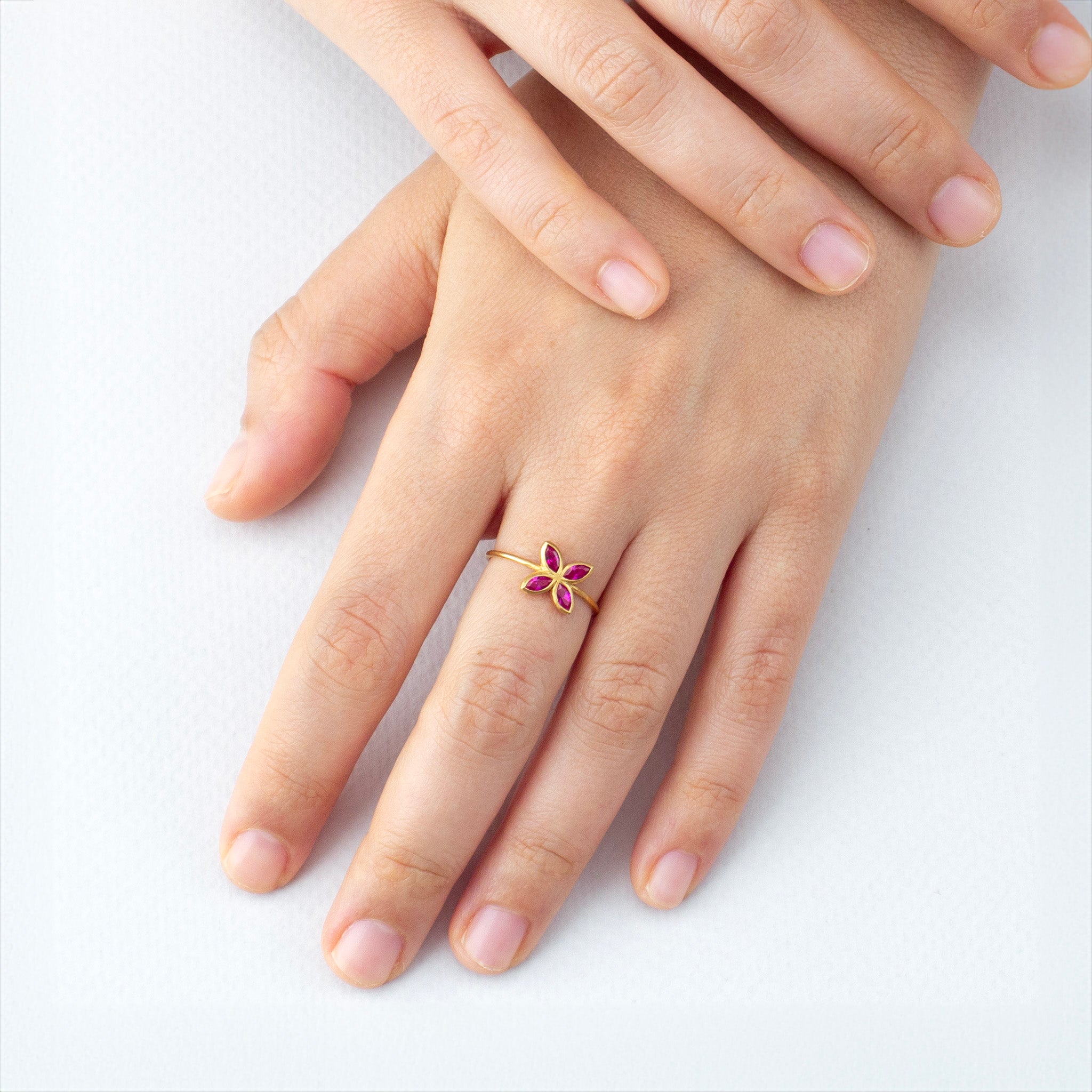 Model wearing the delicate Ruby Marquee Gold ring, its flower-shaped design and radiant color making it a stunning and cheerful accessory for any outfit.