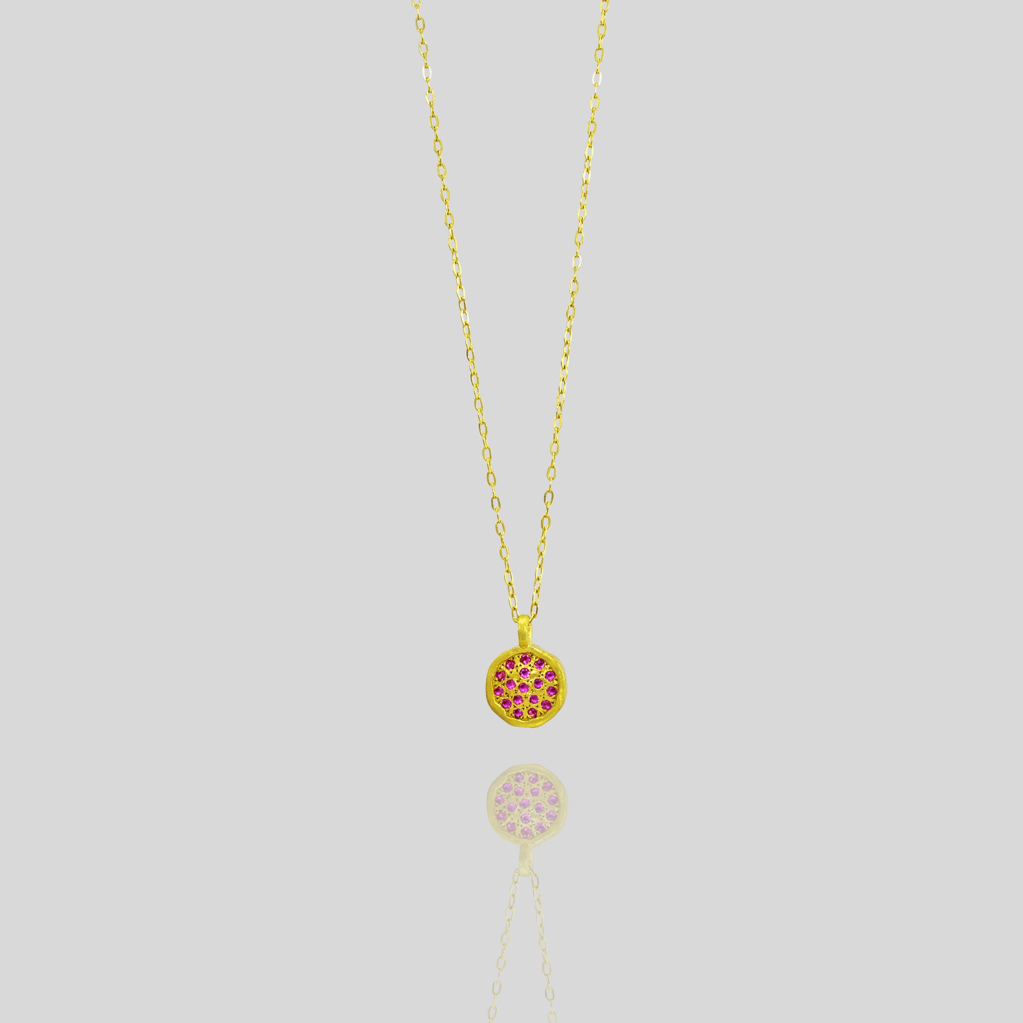 Starlit gold pendant, exquisitely handmade from Yellow Gold, featuring a small gold plate lavishly adorned with scattered Rubies, evoking visions of a vibrant starry night.