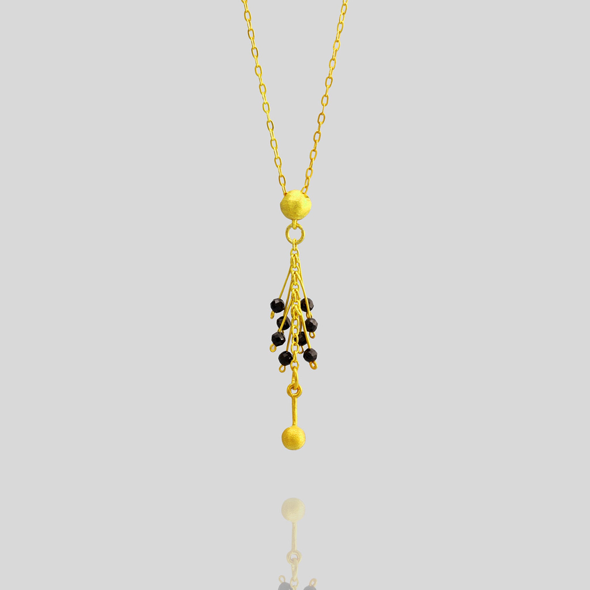 close up of an Elegant Venus Pendant in 18-Carat Gold with Onyx Beads - Detailed Half Cap and Fine Gold Threads Design.